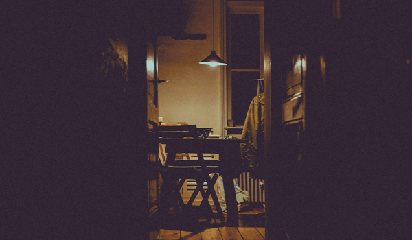 A photograph of a dimly lit nook in an apartment where a writing desk is set up