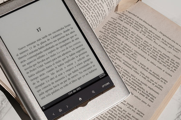 e-reader on top of book with a marked page