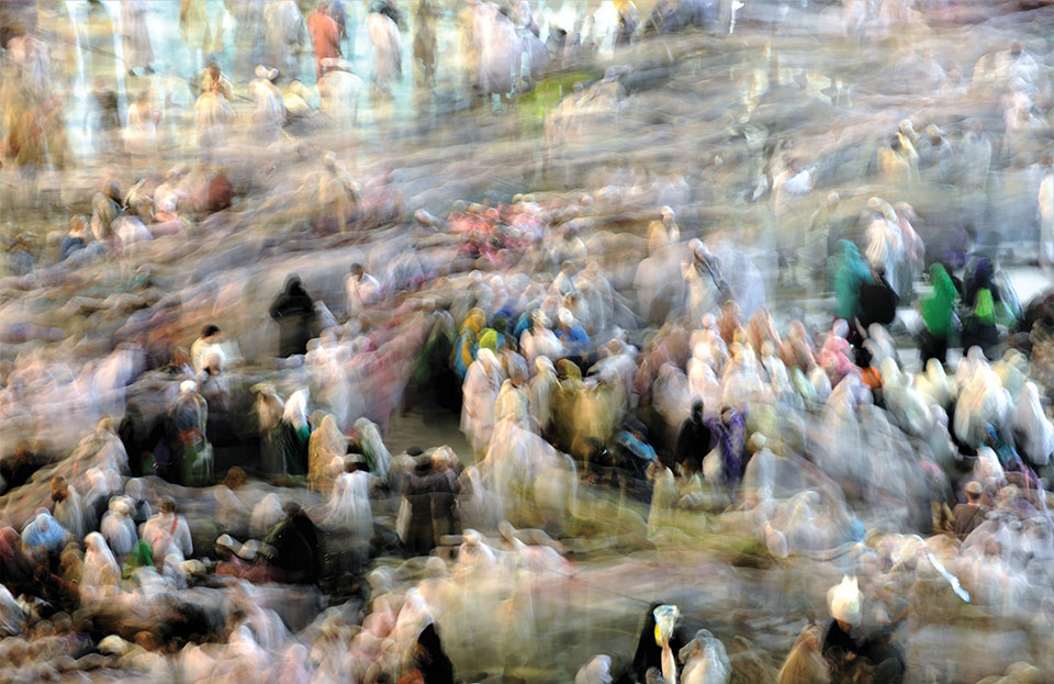 A photograph featuring many people that is blurred to create the effect of an Impressionist painting