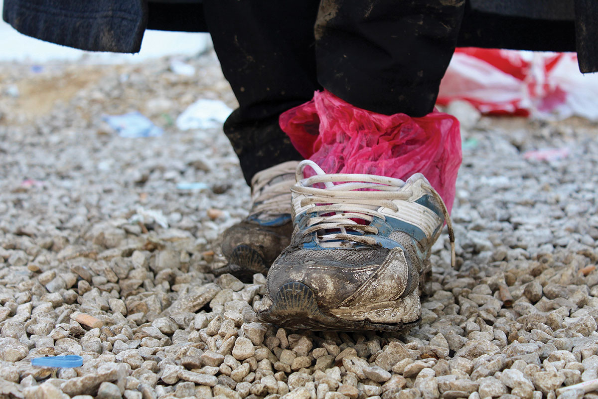A refugee’s shoes are worn, wet, and muddy after a long journey. These shoes are owned by Ali, a Yazidi refugee who traveled from Iraq to Preševo, Serbia, to avoid persecution.  Photo: Meabh Smith / Trócaire