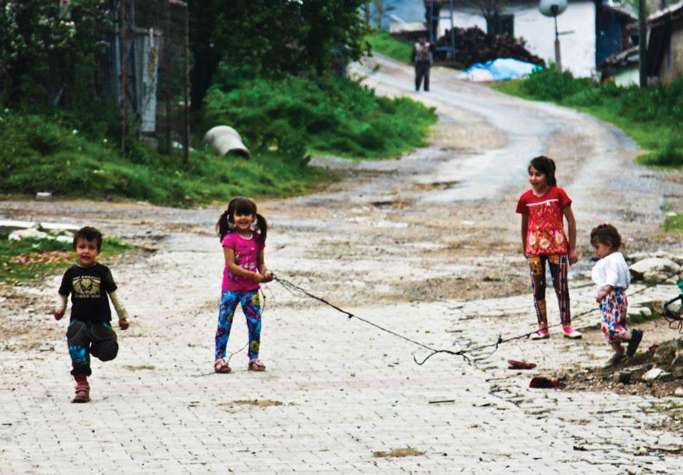 Children idly play tug of war with a discarded piece of chain