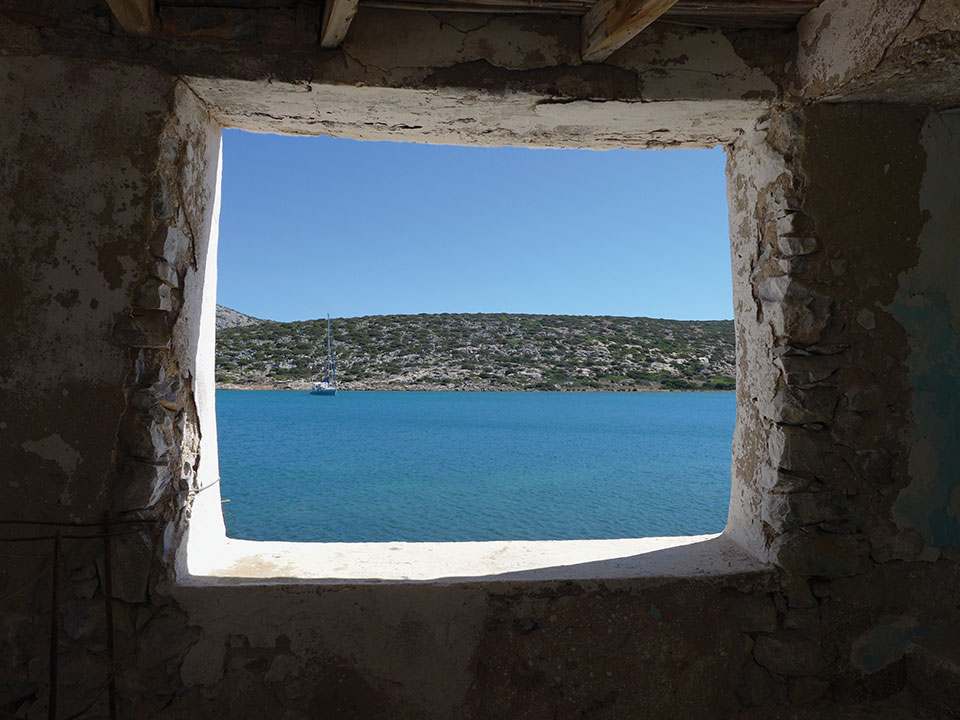 The sea and opposing shoreline as seen through a rugged window