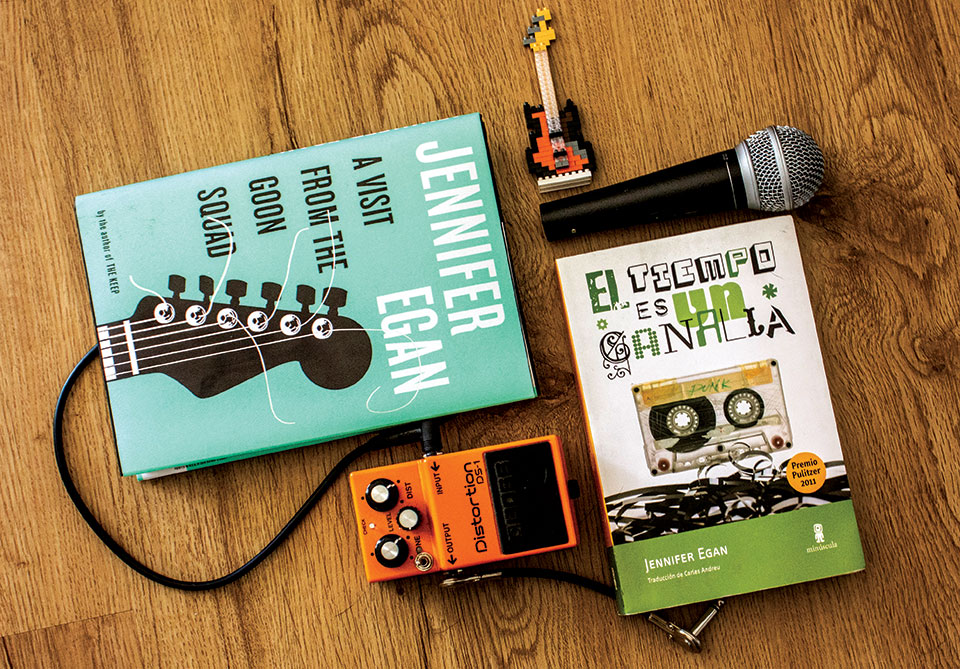 Copies of Jennifer Egan's A Visit from the Good Squad & (in translation) El tiempo es un canalla with a microphone, guitar pedal, and small guitar keychain