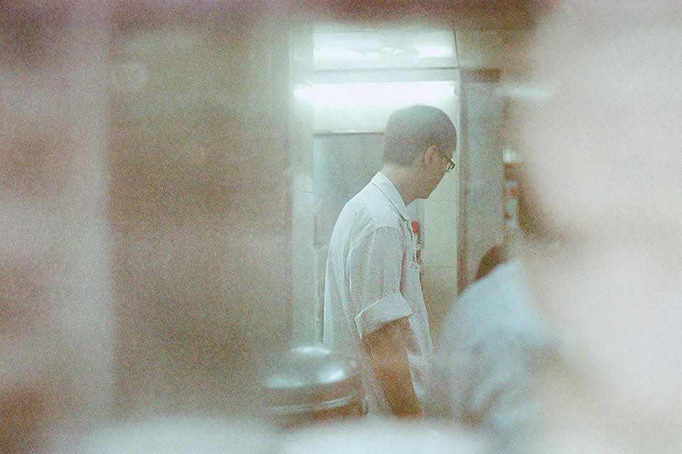A gauzy photo of a waiter in Hong Kong working in a kitchen