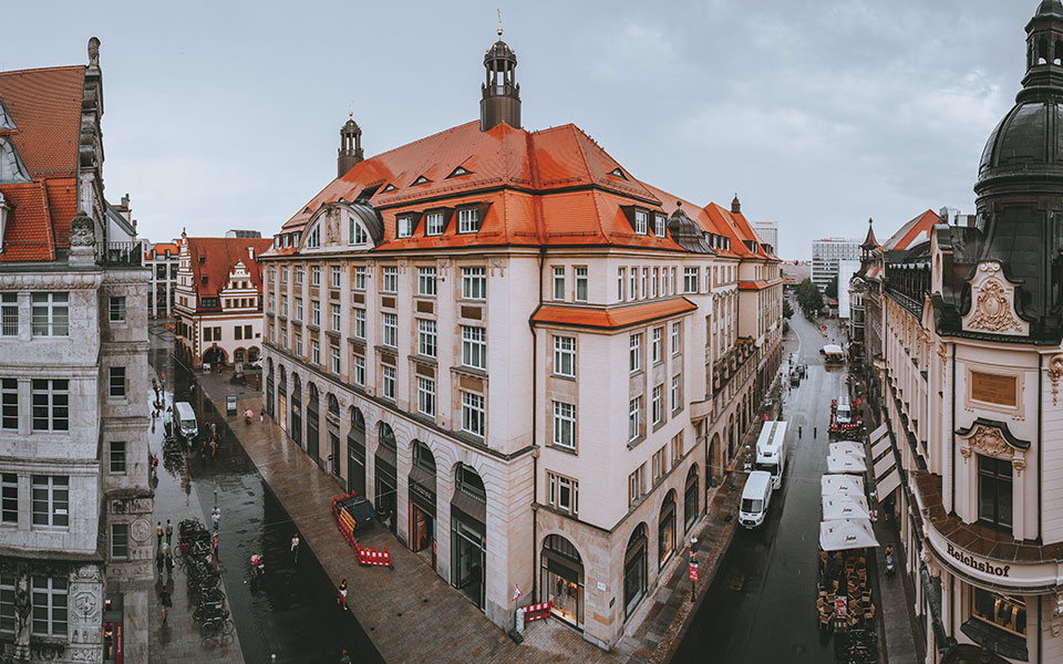 A panaroma shot of Leipzig with a large building protruding in the foreground