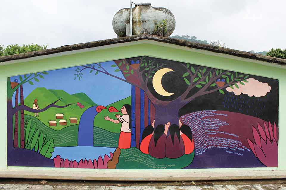 A photograph of a mural, containing several human figures, on the side of a building