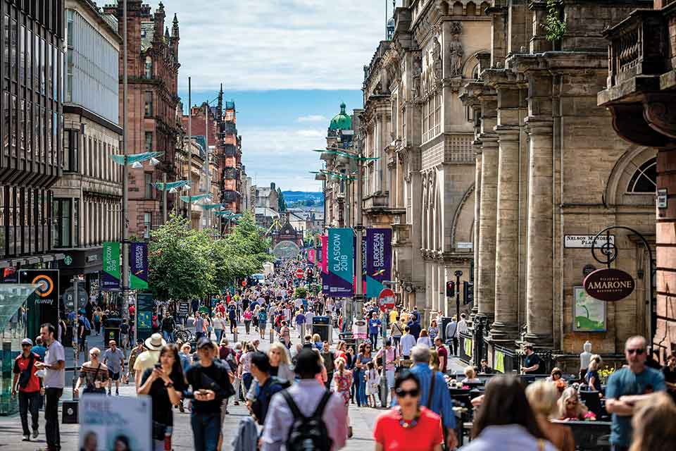 A photograph of a busy street, filled with people, in Glasgow