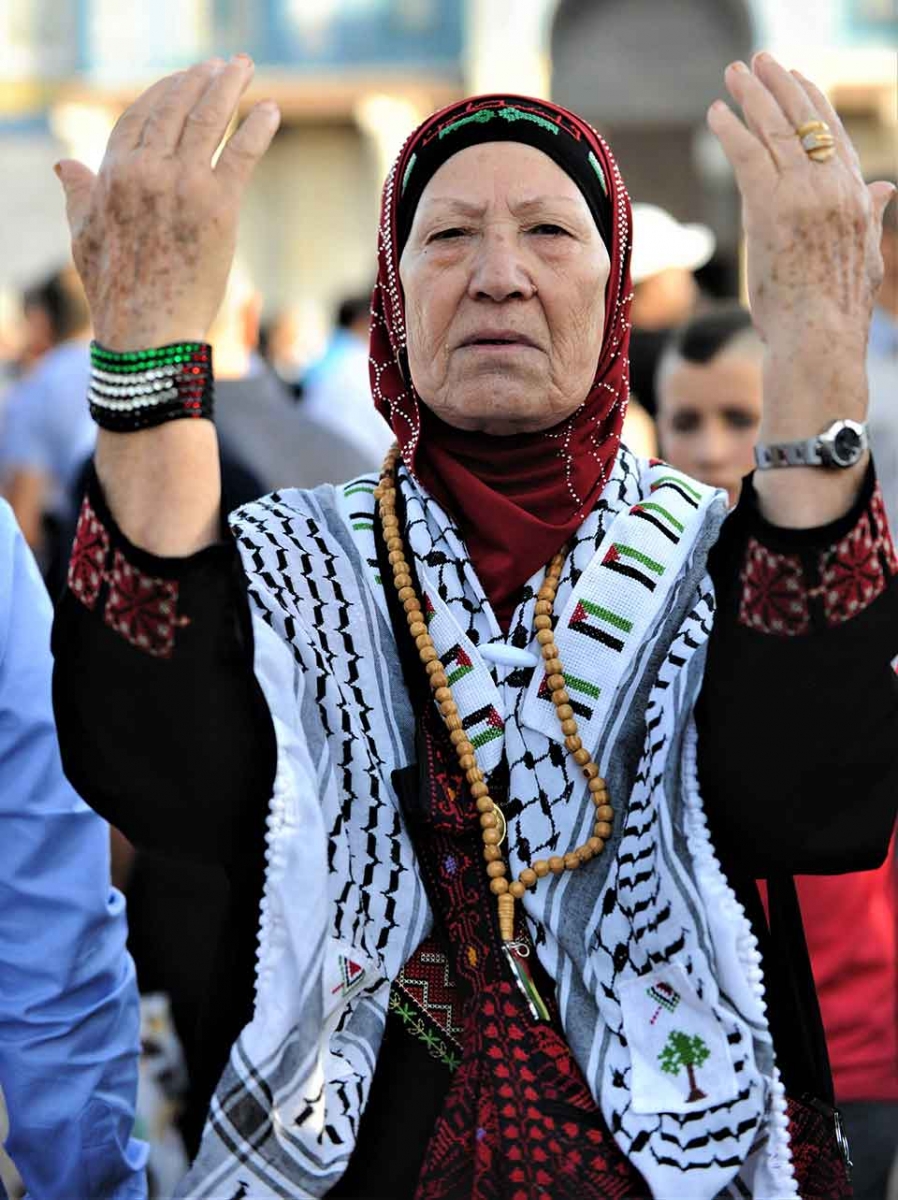 Palestinian woman with upraised hands