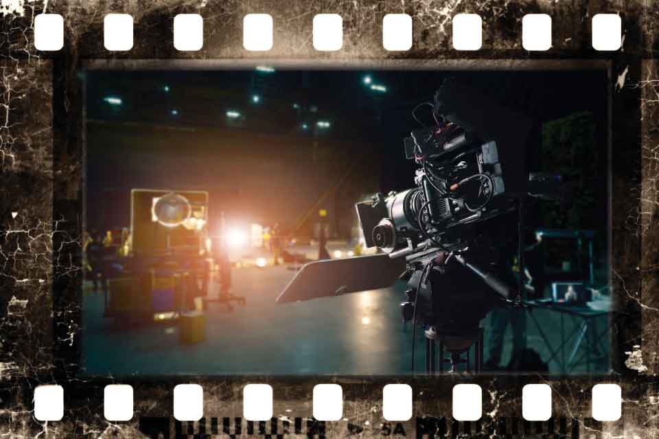 A photograph of a camera on the set of a film. The borders are styled to look like a piece of analog film