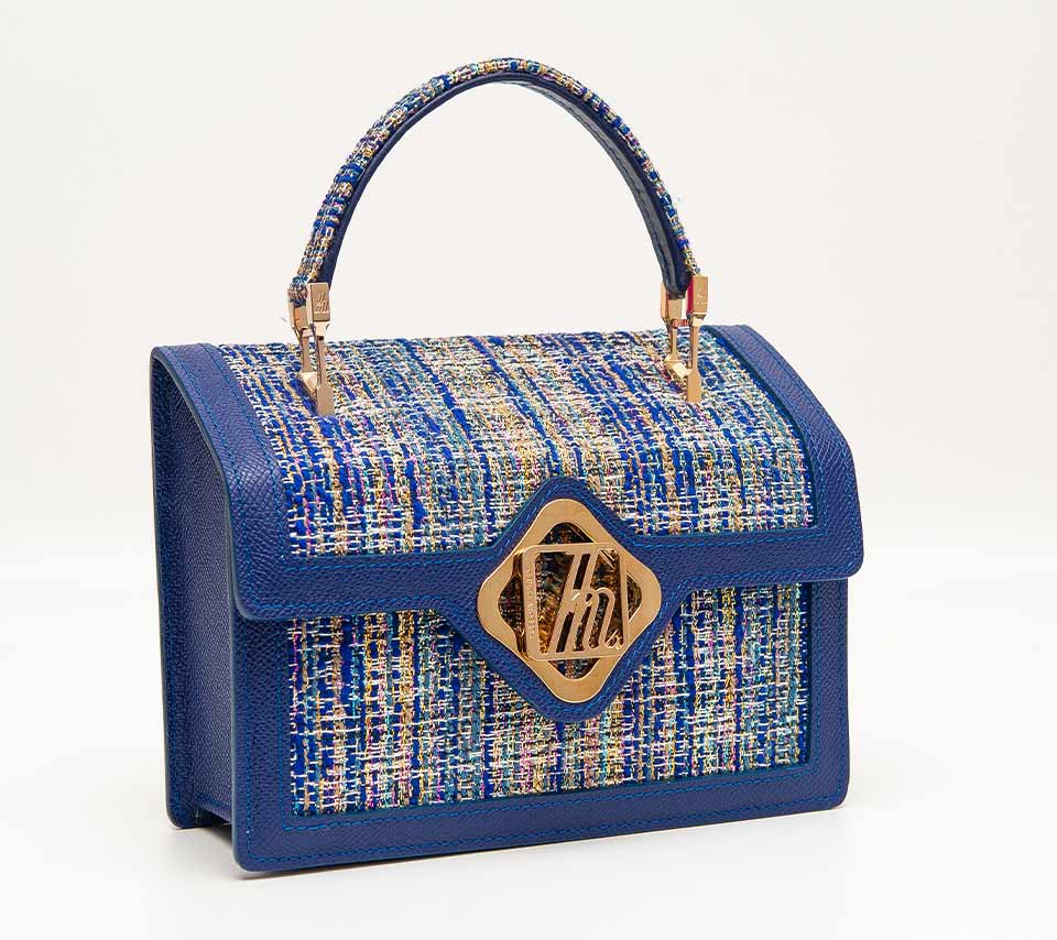 A photograph of an elaborately embellished blue handbag
