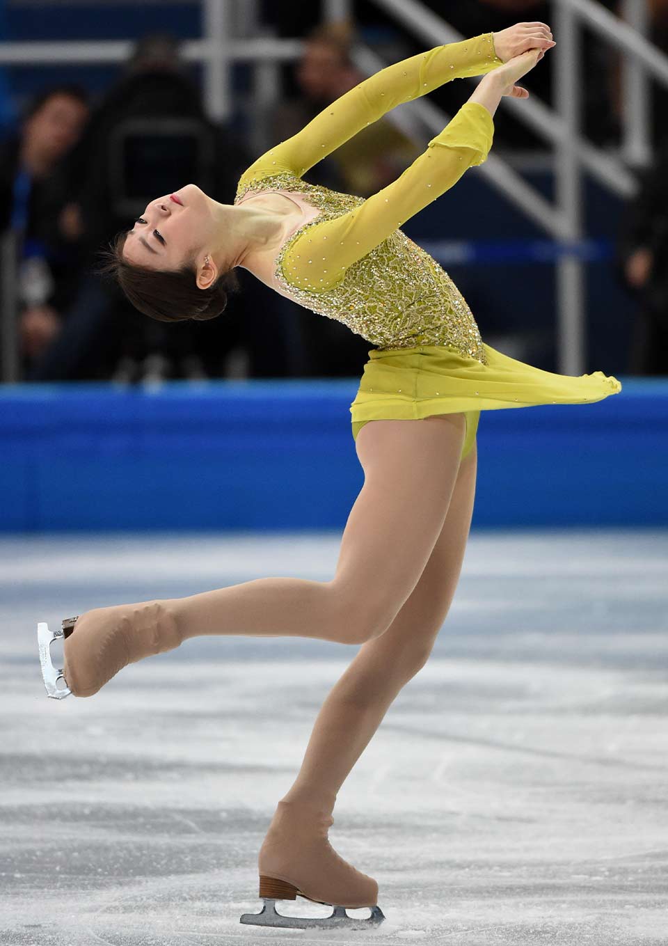 A photograph of an ice skater in performance garb at a competition