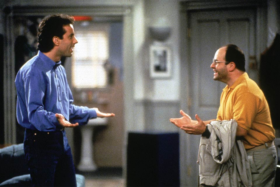 A photo still from the show Seinfeld featuring Jerry Seinfeld (played by Jerry Seinfeld) and George Constanza (played by Jason Alexander)