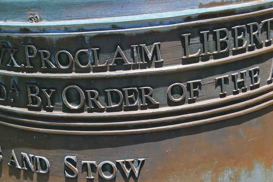 A detail from a photograph of the Liberty Bell. Incomplete text reads: Proclaim Liberty. By Order of the. . .