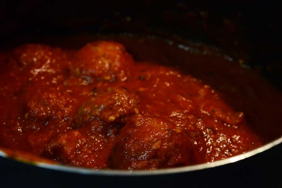 A photograph of meatballs in tomato sauc