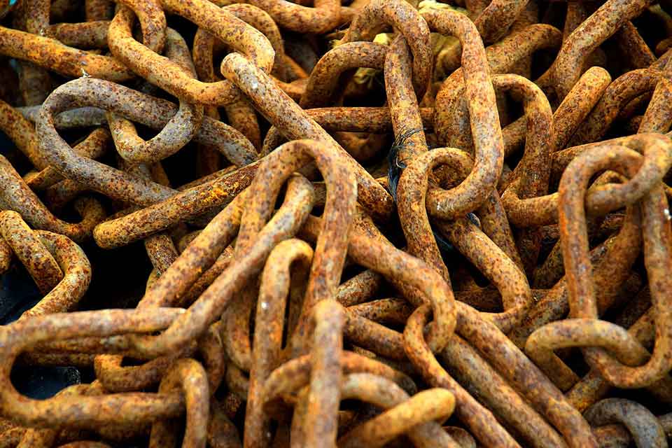 A photograph of a pile of rusted chains