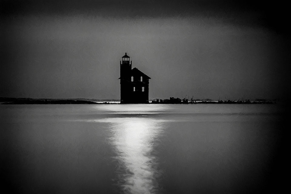 A black and white photograph of a building surrounded by water at night