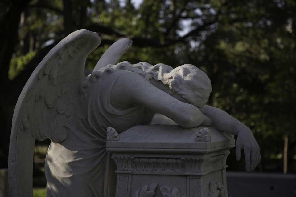A sculpted angel throws herself across a grave in a show of grief