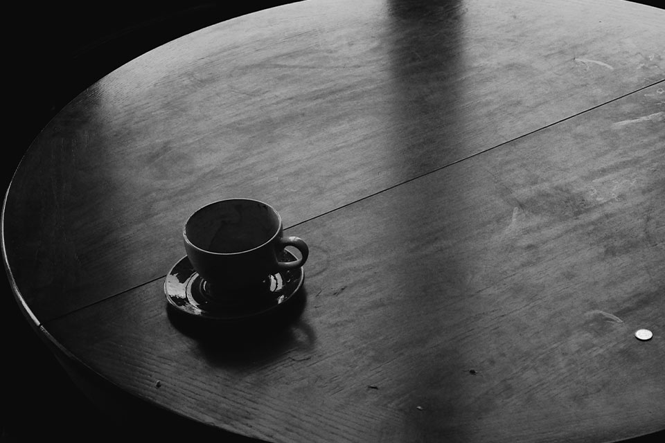 A photograph of a coffee cup on a table from above