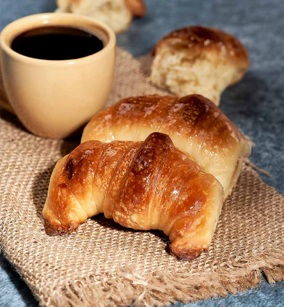 A photograph of coffee and croissants