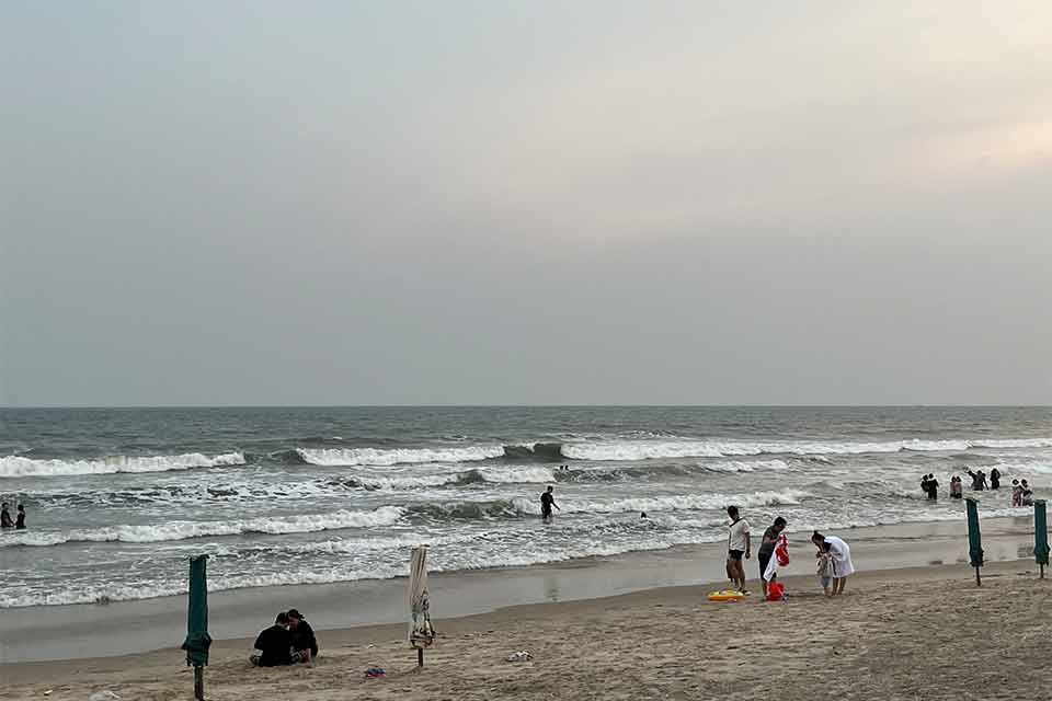 A photograph of people cleaning up a beach