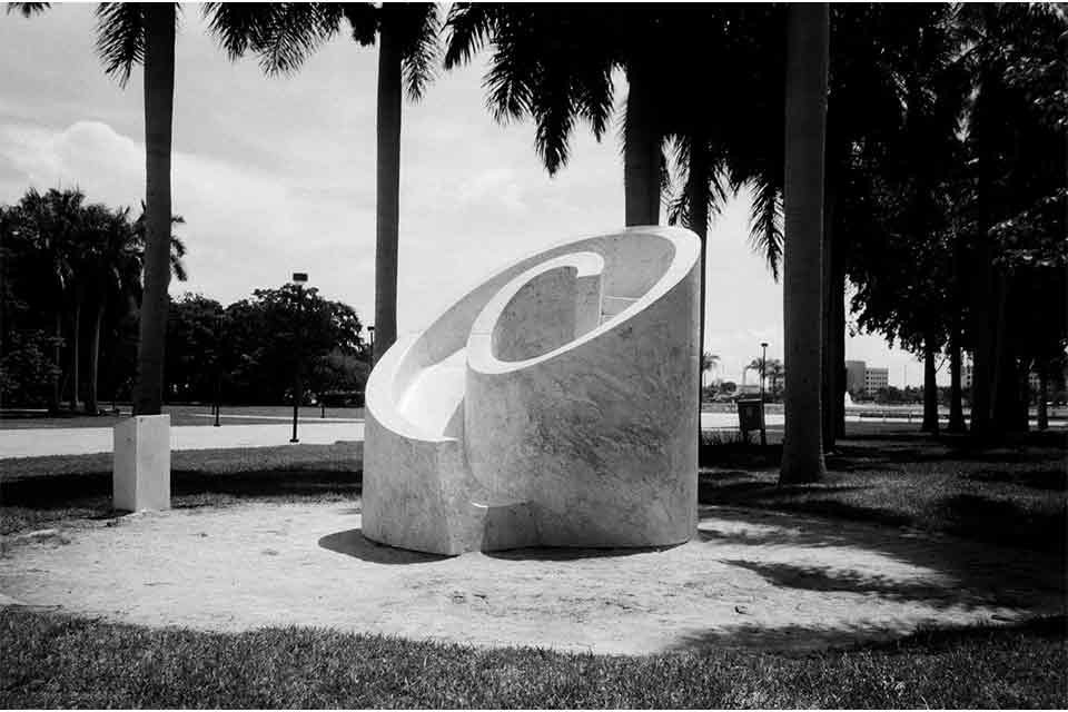 The sculpture from the anchor above, now seen in its context on a stone pavillion surrounded by palm trees