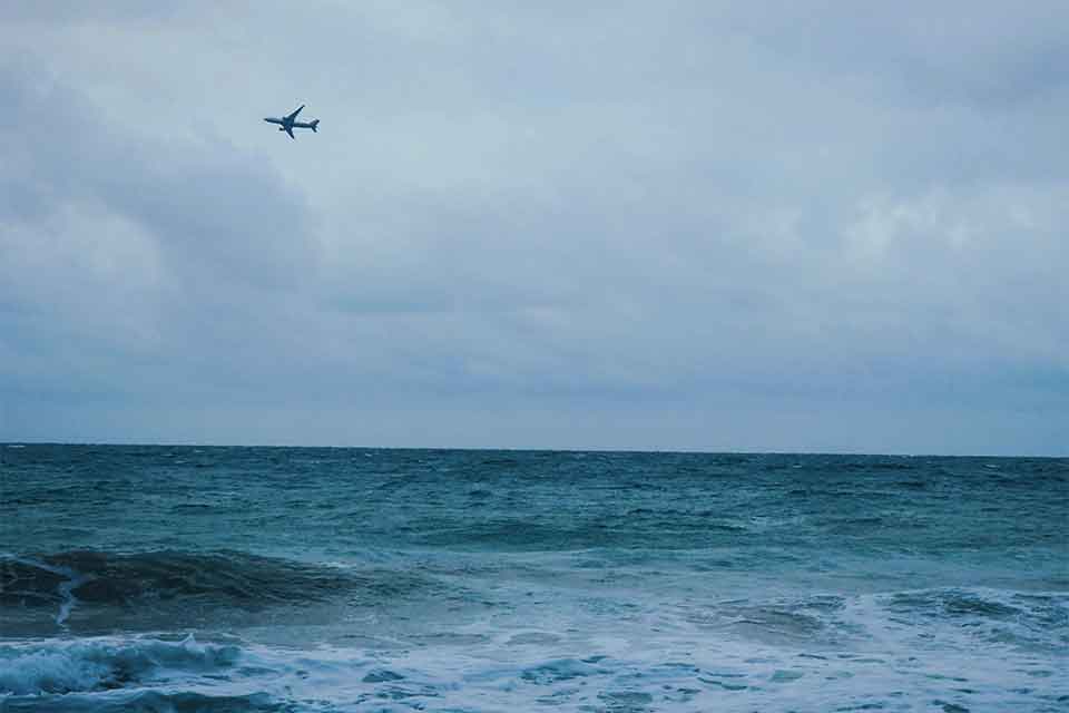 A stormy sea churning beneath a grey-blue, cloud-choked sky