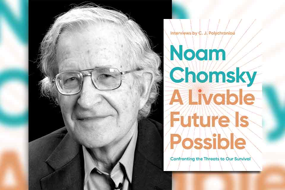 Noam Chomsky with the cover to his book A Livable Future Is Possible