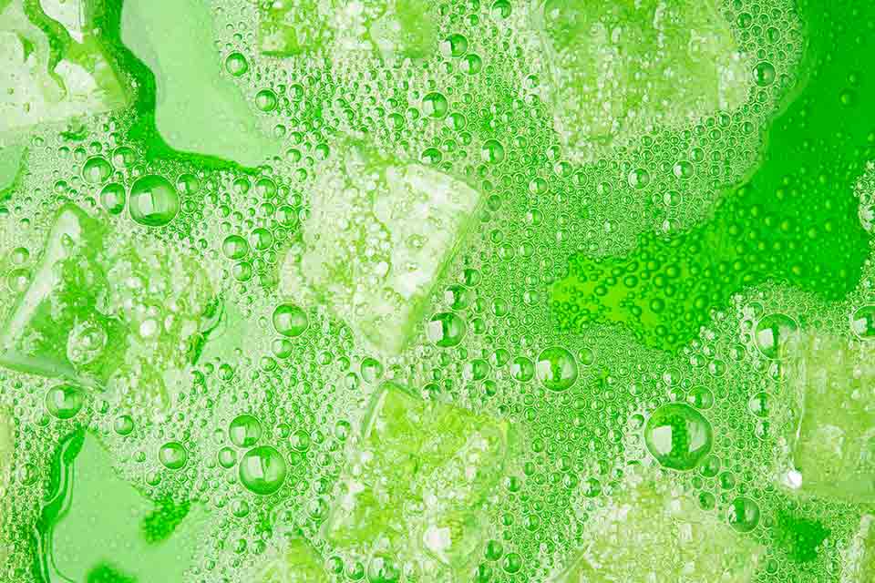 Ice-cubes floating in a fizzy green liquid