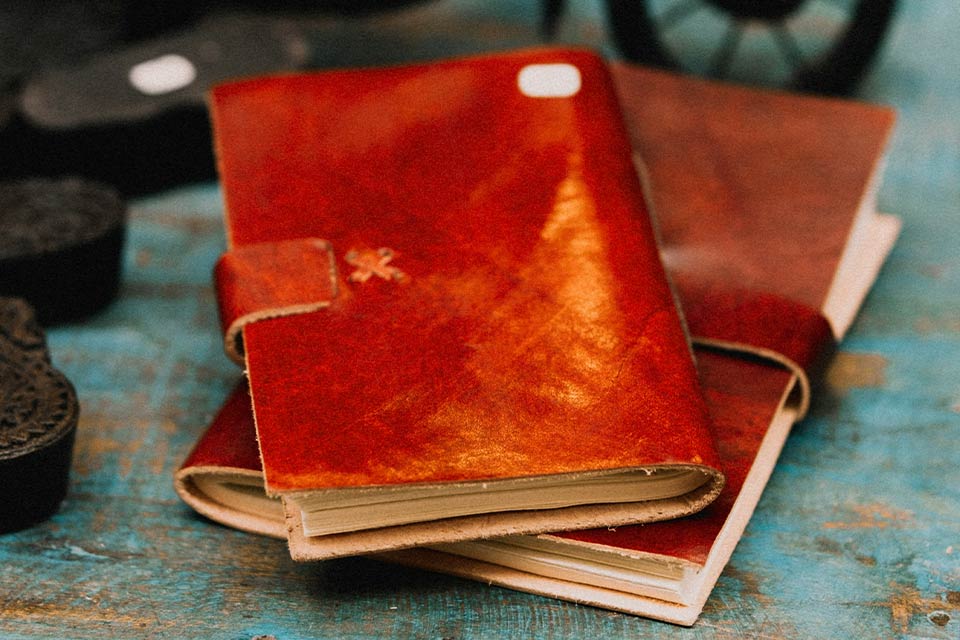 A photograph of two leather bound journals in a pile