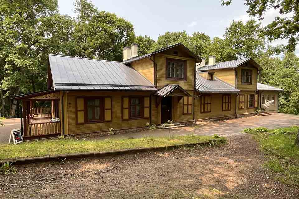 The Markučiai Manor Museum: A rough hewn wooden home surrounded by trees