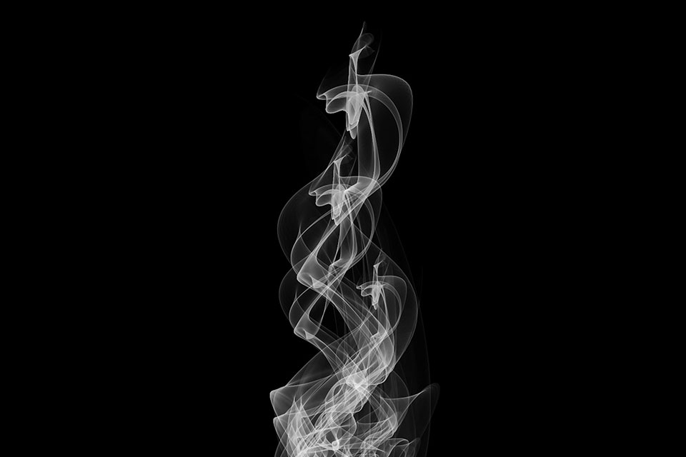 A black and white photo of time-exposed lights in darkness