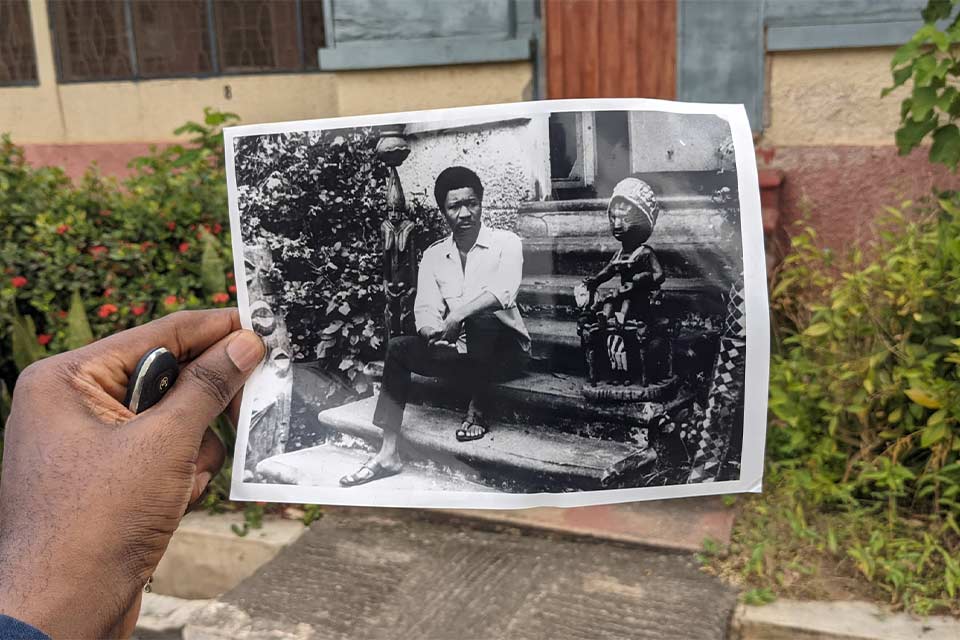 A photograph of a person holding a photograph of Wolé Soyinka