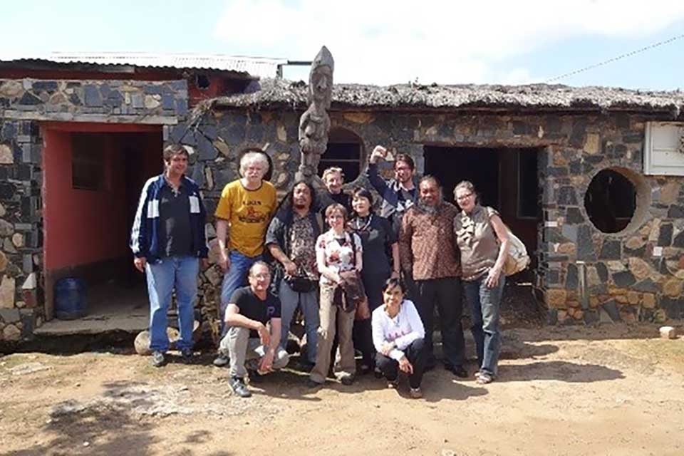 A group of people standing in front of a weathered rural building