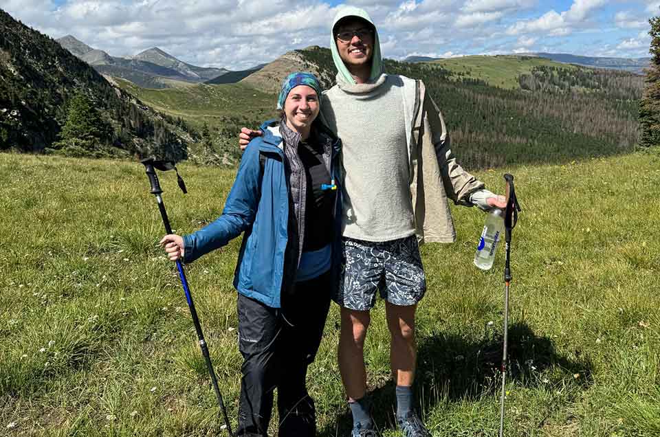 A photograph of the authors smiling on the summit of a mountainside