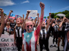 Women, arms raised in defiance, gather in protest