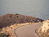 A faded color photograph of a mountain road winding out of view