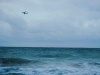 A stormy sea churning beneath a grey-blue, cloud-choked sky