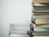 A photograph of a stack of books against a neutral white background