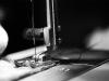 A black and white photograph showing a close up of a sewing machine at work