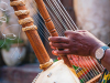 A close-up photograph of Sona Jobarteh's hands playing a kora.