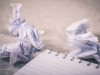 Pieces of paper wadded up next to a pad