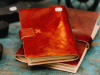 A photograph of two leather bound journals in a pile