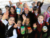 A photograph of a group of Palestinian children in school uniforms smiling for the camera which is above them