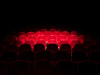 A row of theater seats, all but swallowed up by the darkness save for a spotlight on the inner circle
