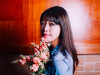 A photograph of Jane Wong holding a bouquet of flowers