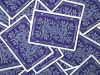 Playing cards with a stylized blue background are scattered on a flat surface