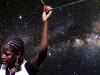 A girl holds a taut wire above her head with deep space in the background