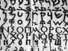 A photograph of the alphabet, each line in a different script, painted on a loose, white cloth