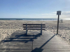 A photograph of an empty bench facing the ocean