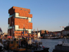 A blocky, multi-story building rises out of a river in Antwerp